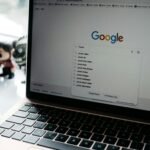 A close-up shot of a laptop displaying a Google search page with related searches visible.