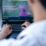 Focused shot of a man using ChatGPT on laptop. Ideal for tech-related content.